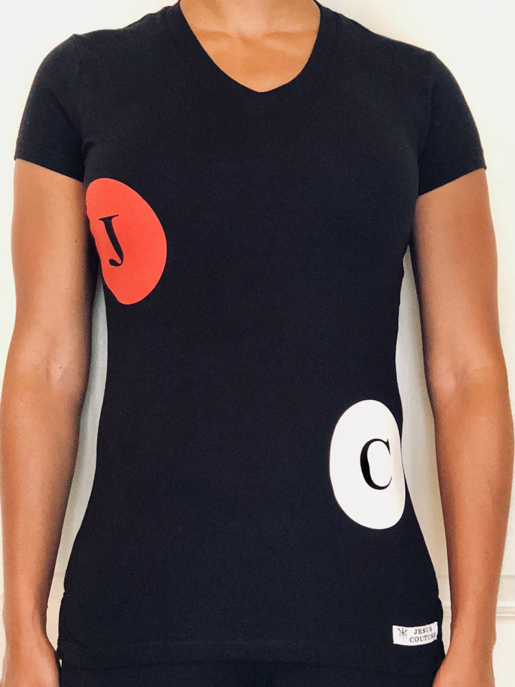 Short-sleeved black V-neck shirt that has a red circle with a “J” and a white circle with a “C” on it.